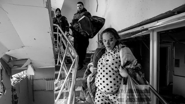 Seorang wanita hamil yang terluka berjalan di lantai bawah di rumah sakit bersalin yang rusak akibat penembakan di Mariupol, Ukraina, Rabu (9/3/2022). Foto: Evgeniy Maloletka/AP Photo
