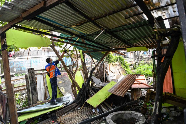 Petugas PT KAI Daop 1 Jakarta berusaha merobohkan bangunan saat penertiban bangunan liar di sekitar lintasan kereta api di Stasiun Ancol hingga Stasiun Tanjung Priok, Jakarta, Senin (14/3/2022).  Foto: M Risyal Hidayat/Antara Foto