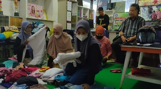 Pengurus dan pengelola PKBM Sakila Kerti menyiapkan baju baru dan pantas pakai sebelum dibagikan kepada para pengasong dan warga yang beraktivitas di Terminal Bus Kota Tegal, Sabtu (30/4/2022).