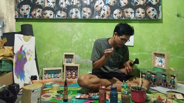 Hasan Agus Wiratomo sedang melukis boneka dari limbah kayu. Sumber foto: Instagram @hasan_agus