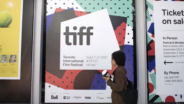 Seorang wanita berjalan melewati logo Tiff selama Festival Film Internasional Toronto 2017. Foto: Valerie Macon / AFP