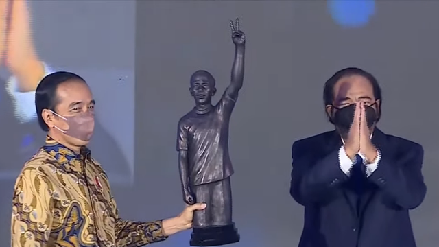 Presiden Joko Widodo menerima patung dari Ketua NasDem Surya Paloh di acara HUT ke-10 Partai Nasdem di Jakarta, Kamis, 11 November 2021. Foto: Youtube/NasDem TV