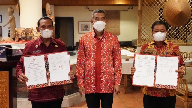 Plt Direktur Jenderal Kekayaan Intelektual Kemenkumham Razilu (tengah) menyaksikan penandatanganan MoU antara Pemkab Toraja Utara dan Kanwil Kemenkumham Sulsel tentang Pelindungan dan Pemanfaatan KI di Toraja Heritage Hotel pada Rabu (23/3). Foto: DJKI Kemenkumham