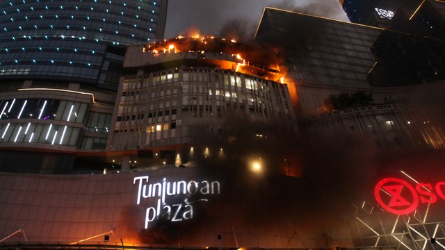 Kobaran api muncul dari Tunjungan Plaza 5 yang terbakar di Surabaya, Jawa Timur, Rabu (13/4/2022). Foto: Didik Suhartono/Antara Foto