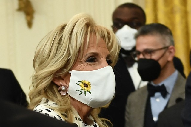 Ibu negara AS Jill Biden mengenakan masker bunga matahari, bunga nasional Ukraina, untuk mendukung rakyat Ukraina, selama acara merayakan Bulan Sejarah Hitam di Ruang Timur Gedung Putih 28 Februari 2022, di Washington, DC. Foto: Brendan Smialowski / AFP