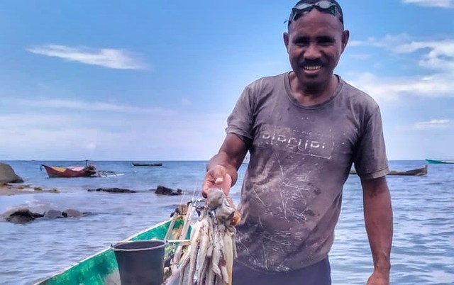 Keterangan foto:Nelayan penangkap gurita, Andreas (52 tahun) menunjukkan gurita hasil tangkapannya. Foto: Mario WP Sina.