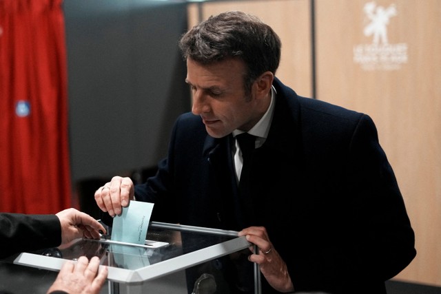 Presiden Prancis Emmanuel Macron memberikan suaranya pada hari putaran pertama pemilihan presiden, di Le Touquet, Prancis. Foto: Thibault Camus/Pool via REUTERS