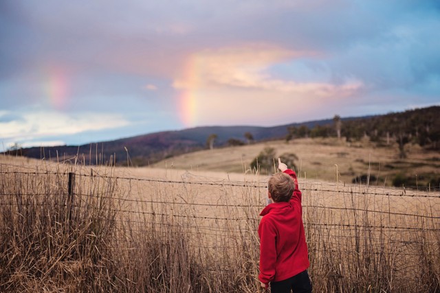 Foto anak laki-laki sedang menunjuk ke pelangi. Foto: Pexels/Kat Smith.