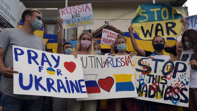 Ratusan Warga Negara Asing (WNA) asal Ukraina bersama simpatisan membawa poster berisi pesan untuk Rusia agar menghentikan invasi terhadap Ukraina saat aksi damai di Kantor Konsulat Ukraina, Denpasar, Bali, Selasa (1/3/2022). Foto: Nyoman Hendra Wibowo/ANTARA FOTO