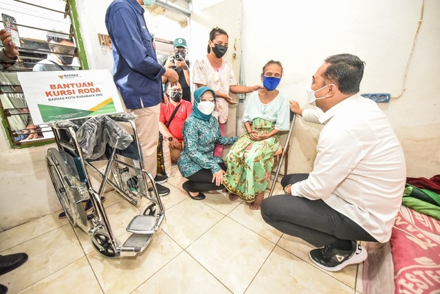 Wali Kota Surabaya Eri Cahyadi, beserta Ketua Tim Penggerak (TP) PKK Kota Surabaya, Rini Indriyani, saat memberikan bantuan kursi roda kepada salah satu penyandang disabilitas. Foto-foto: Diskominfo Kota Surabaya