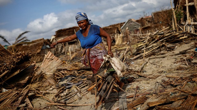 Seorang wanita membawa potongan-potongan kayu, setelah Topan Batsirai, di kota Mananjary, Madagaskar, 8 Februari 2022. Foto: Alkis Konstantinidis/REUTERS
