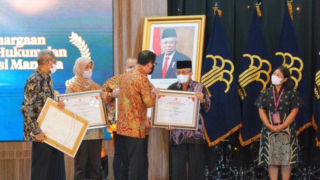 Menkumham Yasonna H Laoly memberi penghargaan kepada Taufiq Ismail pada acara Puncak Peringatan Hari Kekayaan Intelektual Sedunia tahun 2022 di Graha Pengayoman, Selasa (26/4/2022). Foto: DJKI Kemenkumham