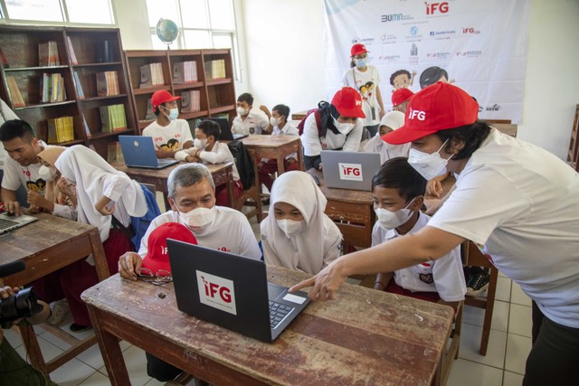 SEVP Pengembangan Bisnis IFG Rosmaylinda Nasution (kanan) bersama Sekretaris Perusahaan Indonesia Financial Group (IFG) Beko Setiawan (kiri) memberikan edukasi digital kepada siswa sekolah dasar SDN 01 Malasari. Foto: Aditia Noviansyah/kumparan