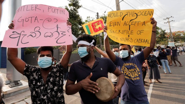 Orang-orang memegang poster menentang Presiden Sri Lanka Gotabaya Rajapaksa setelah pemerintah memberlakukan jam malam di Kolombo, Sri Lanka, Minggu (3/4/2022). Foto: Dinuka Liyanawatte/REUTERS