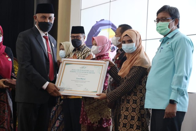 Gubernur Sumatera Barat Mahyeldi menyerahkan penghargaan kepada salah seorang perempuan di Sumatera Barat, Kamis 21 April 2022. Foto: dok Diskominfotik