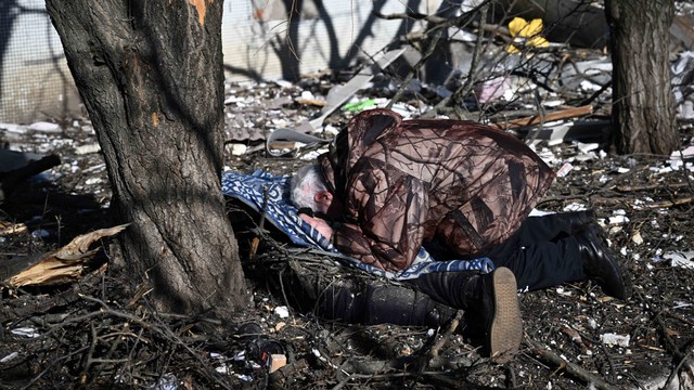 Seorang menangis di tubuh seorang kerabat di luar gedung yang hancur setelah pemboman di kota Chuguiv di Ukraina timur pada 24 Februari 2022. Foto: Aris Messinis/AFP