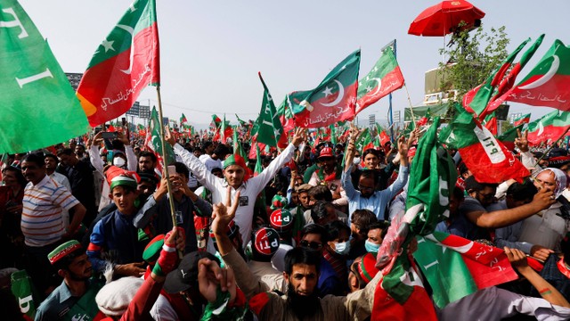 Pendukung Perdana Menteri Pakistan Imran Khan, ketua partai politik Pakistan Tehreek-e-Insaf (PTI), mengibarkan bendera saat mereka menghadiri rapat umum di Islamabad, Pakistan, Minggu (27/3/2022).
 Foto: Akhtar Soomro/REUTERS