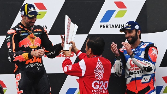 Presiden Joko Widodo memberikan piala kepada pembalap Red Bull KTM Factory Racing Miguel Oliveira (kiri) pemenang MotoGP Indonesia 2022 di Sirkuit Mandalika, Minggu (20/3/2022). Foto: Andika Wahyu/ANTARA FOTO