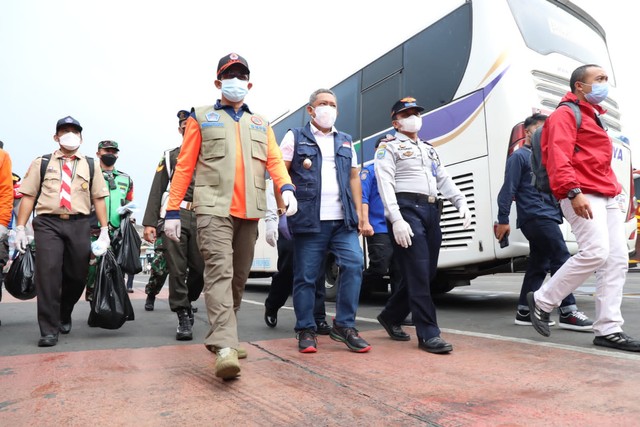 Kepala BNPB Letjen TNI Suharyanto membagikan masker kepada warga di Pasar Baru dan Terminal Cicaheum, Kota Bandung pada Sabtu (19/2). Foto: Dok. BNPB