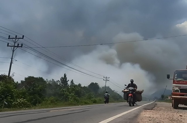 Kepulan asap tebal terlihat di jalan raya Kabupaten Mempawah. Foto: M.Zain/Hi!Pontianak