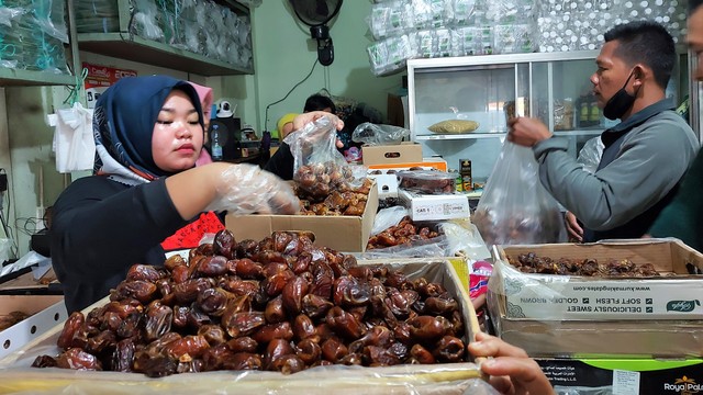 Pedagang menata kurma di salah satu toko di Jalan Kapten Mulyadi, Solo, Sabtu (02/04/2022)