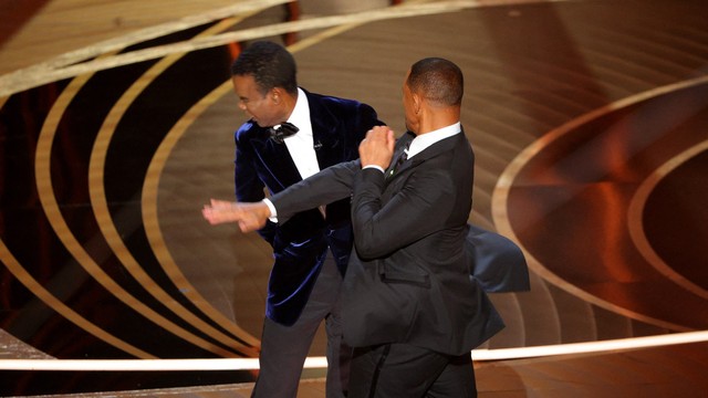 Will Smith (kanan) menampar Chris Rock saat Rock berbicara di atas panggung selama Oscars ke-94 di Hollywood, Los Angeles, California, AS, 27 Maret 2022.  Foto: REUTERS/Brian Snyder