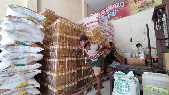 Pekerja di sebuah toko sembako di Pasar Kliwon Rejo Amertani Temanggung, menangkut minyak goreng, Jumat (18/3/2022). Foto: ari/Tugu Jogja