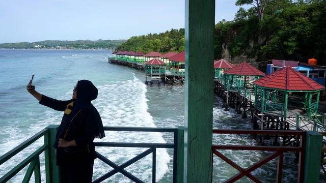 Pengunjung juga bisa berjalan dan berfoto di sepanjang dermaga sambil menikmati pemandangan tebing pegunungan. Foto: Akbar Tado/Antara Foto