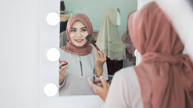 Ilustrasi perempuan berhijab sedang make up. Foto: Odua Images/Shutterstock