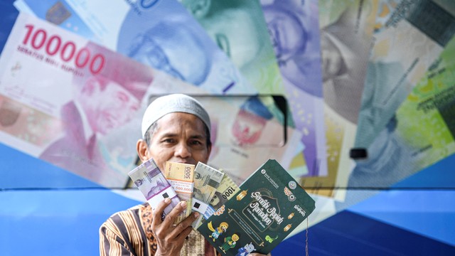 Warga menunjukkan uang baru yang ditukarkan pada mobil kas keliling Bank Indonesia (BI) di Pasar Koja Baru, Jakarta Utara, Rabu (13/4/2022). Foto: M Risyal Hidayat/ANTARA FOTO