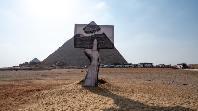 Sebuah instalasi berjudul Greetings From Giza oleh seniman dan fotografer Prancis Jean Rene, yang dikenal sebagai JR terlihat menghadap piramida di Dataran Tinggi Giza, dekat Kairo, Mesir pada 23 Oktober 2021. Foto: Ammar Abd Rabbo/Art d'Egypte