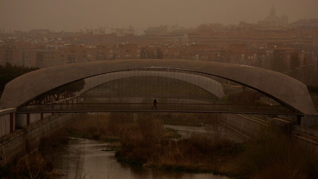 Seseorang yang mengenakan topeng pelindung melintasi jembatan saat badai Celia meniup pasir dari gurun Sahara di atas Madrid, Spanyol, 15 Maret 2022. Foto: Susana Vera/Reuters