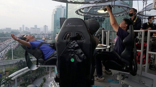 Pengunjung memotret makanan di Lounge In The Sky, Jakarta, Selasa (29/3/2022). Foto: Iqbal Firdaus/kumparan