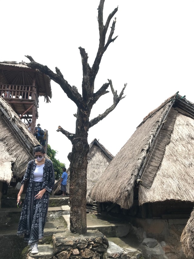 Seorang turis berjalan di samping Pohon Cinta di Desa Sade di Lombok. Foto: Adhie Ichsan/kumparan