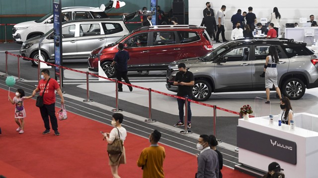 Pengunjung melihat mobil-mobil yang dipamerkan di booth Wuling pada hari terakhir pameran otomotif Jakarta Auto Week 2022 di Jakarta Convention Center, Senayan, Jakarta, Minggu (20/3/2022). Foto: Hafidz Mubarak A/ANTARA FOTO