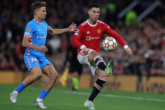 Pemain Manchester United Cristiano Ronaldo berusaha melewati pemain Atletico Madrid Marcos Llorente pada pertandingan leg kedua babak 16 besar Liga Champions di ld Trafford, Manchester, Inggris. Foto: Phil Noble/REUTERS