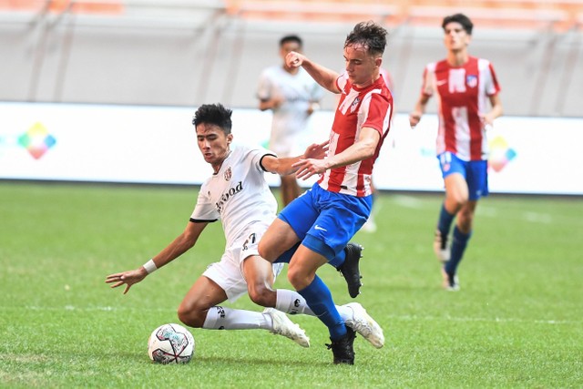 Pemain Atletico Madrid U-18 Hugo Martin Gonzalez berebut bola dengan pemain Bali United U-18 Shava Da Yansa pada pertandingan International Youth Championship (IYC) 2021 di Jakarta International Stadium. Jakarta, Rabu (13/4). Foto: Hafidz Mubarak A/ANTARA FOTO