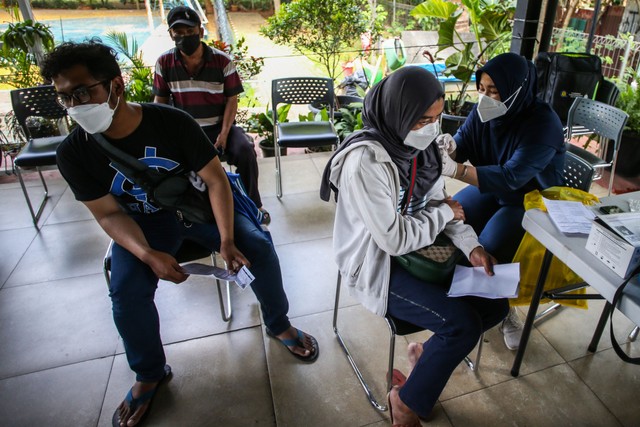 Warga menerima suntikan vaksin COVID-19 dosis ketiga di RPTRA Bhineka, Swadarma, Jakarta, Kamis (24/3/2022). Foto: Rivan Awal Lingga/ANTARA FOTO
