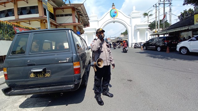 Polisi menyosialisasikan pentingnya penerapan prokes di kawasan Pasar Klewer, Solo, Kamis (24/02/2022). FOTO: Agung Santoso