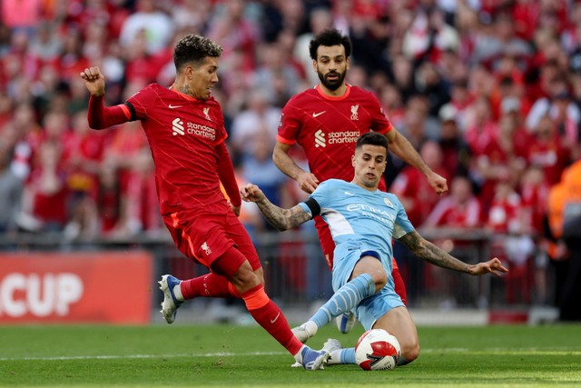 Pemain Manchester City Joao Cancelo beraksi dengan pemain Liverpool Roberto Firmino dan Mohamed Salah di Stadion Wembley, London, Inggris, Sabtu (16/4/2022). Foto: Action Images via Reuters/Carl Recine