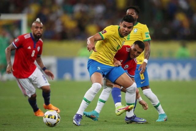 Pemain Brasil Casemiro beraksi dengan pemain Chile Alexis Sanchez di Estadio Maracana, Rio de Janeiro, Brasil, Kamis (24/3/2022). Foto: Ricardo Moraes/REUTERS