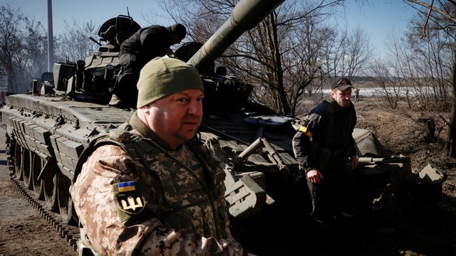 Prajurit Ukraina berjalan di depan tank Rusia yang mereka tangkap setelah pertempuran, di luar Brovary dekat Kiev, Ukraina, Kamis (10/3/2022). Foto: Thomas Peter/REUTERS