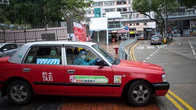 Taksi khusus yang mengangkut pasien COVID-19 melintas di daerah Shau Kei Wan Hong Kong. Foto: BERTHA WANG/AFP