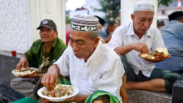Warga menyantap masakan kuah beulangong pada buka puasa bersama di masjid Gampong Ilie, Kota Banda Aceh, Sabtu (23/4/2022). Foto: Suparta/acehkini