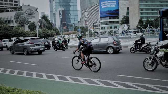Pesepeda melintasi jalan kawasan M.H. Thamrin, Jakarta Pusat, Selasa (22/3/2022). Foto: Jamal Ramadhan/kumparan