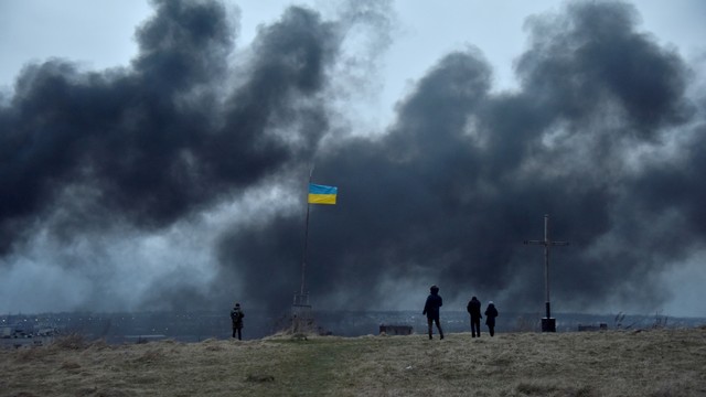 Orang-orang menyaksikan asap membubung setelah serangan udara, saat serangan Rusia di Ukraina berlanjut, di Lviv, Ukraina, Sabtu (26/3/2022). Foto: Pavlo Pamarchuk/REUTERS