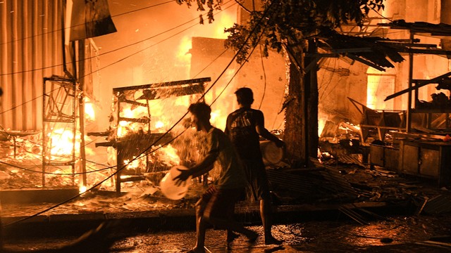 Sejumlah warga memadamkan api yang membakar kios dan rumah di pasar Gembrong, Jatinegara, Jakarta Timur, Minggu (24/4/2022). Foto: Fakhri Hermansyah/ANTARA FOTO