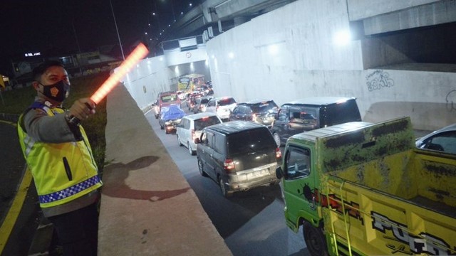 Polisi memantau arus pemudik di akses keluar Gerbang Tol Cileunyi, Kabupaten Bandung, Jawa Barat, Jumat (29/4/2022). Foto: Bagus Ahmad Rizaldi/ANTARA