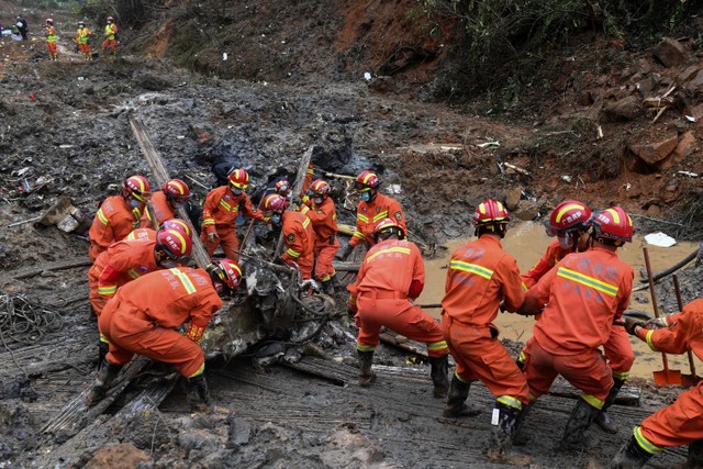 Tim penyelamat menarik puing-puing pesawat China Eastern Airlines di Wuzhou, Daerah Otonomi Guangxi Zhuang, China, pada Kamis (24/3/2022). Foto: Xu Dong/Xinhua via AP PHOTO