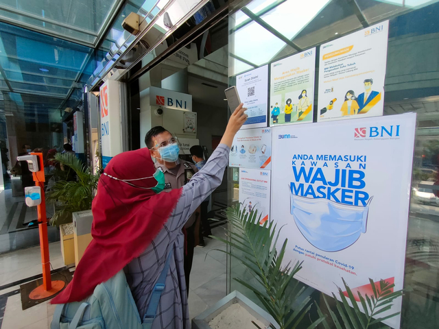 Nasabah melakukan scan aplikasi Peduli Lindungi di kantor layanan BNI di Palembang. Foto: Istimewa